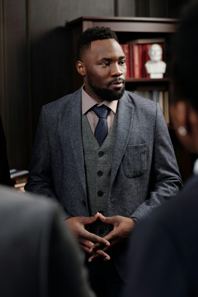 Confident businessman in a suit leading a discussion in a formal office setting.